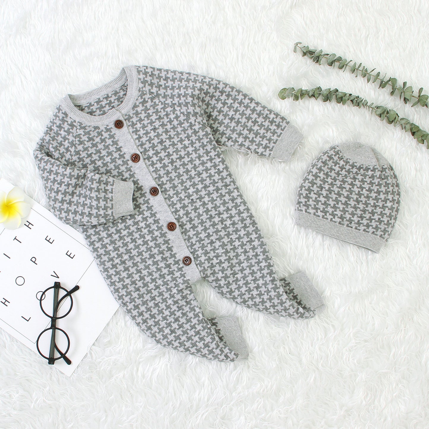 Gray patterned baby outfit with matching hat on a white background