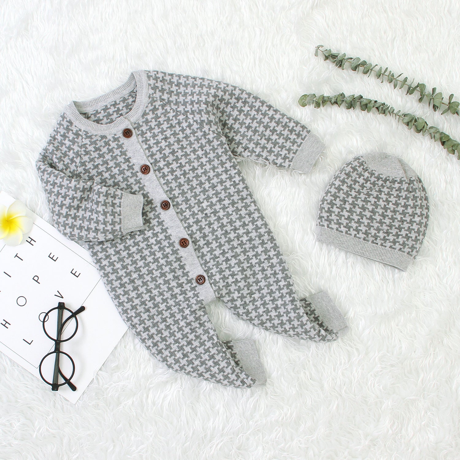 Gray patterned baby outfit with matching hat on a white background