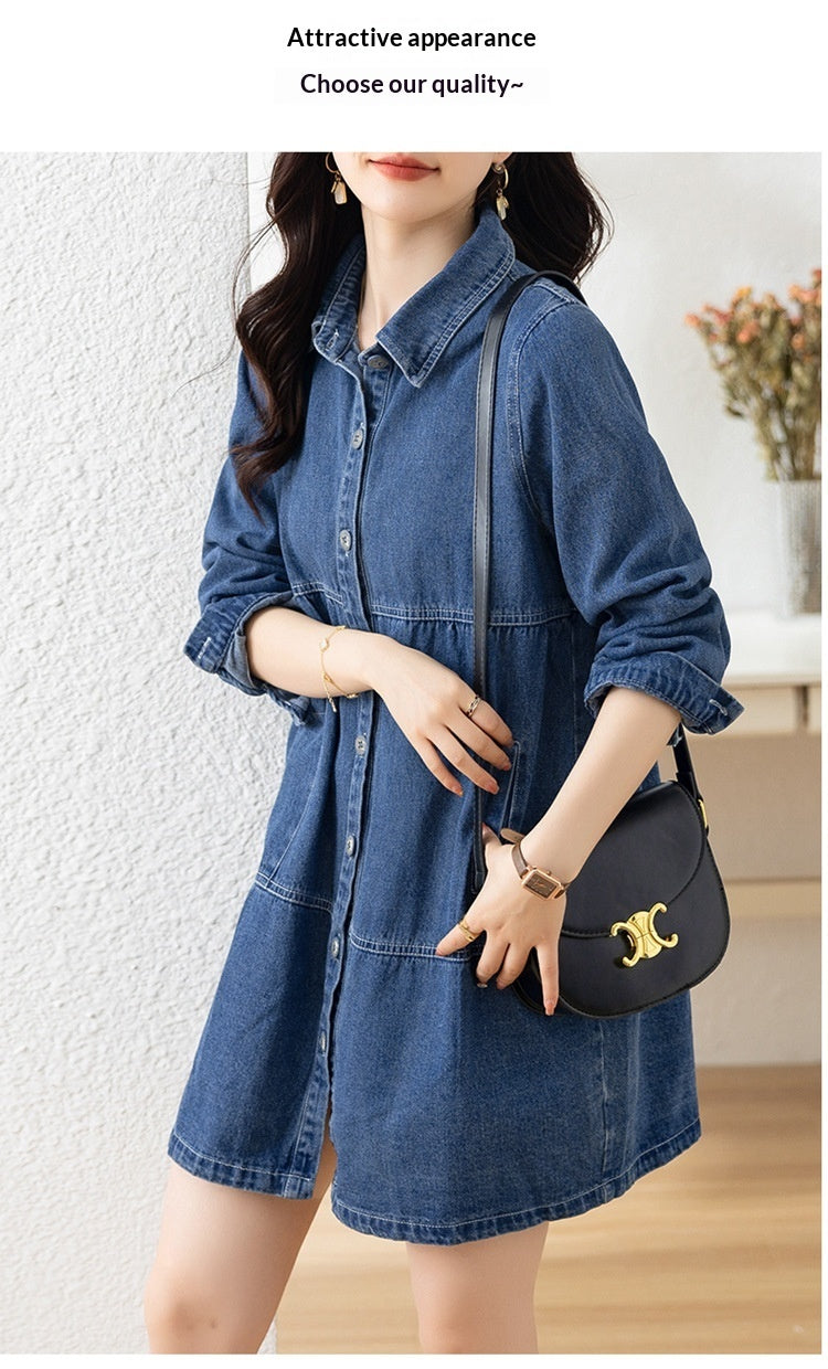 Woman wearing a denim dress holding a black handbag indoors.