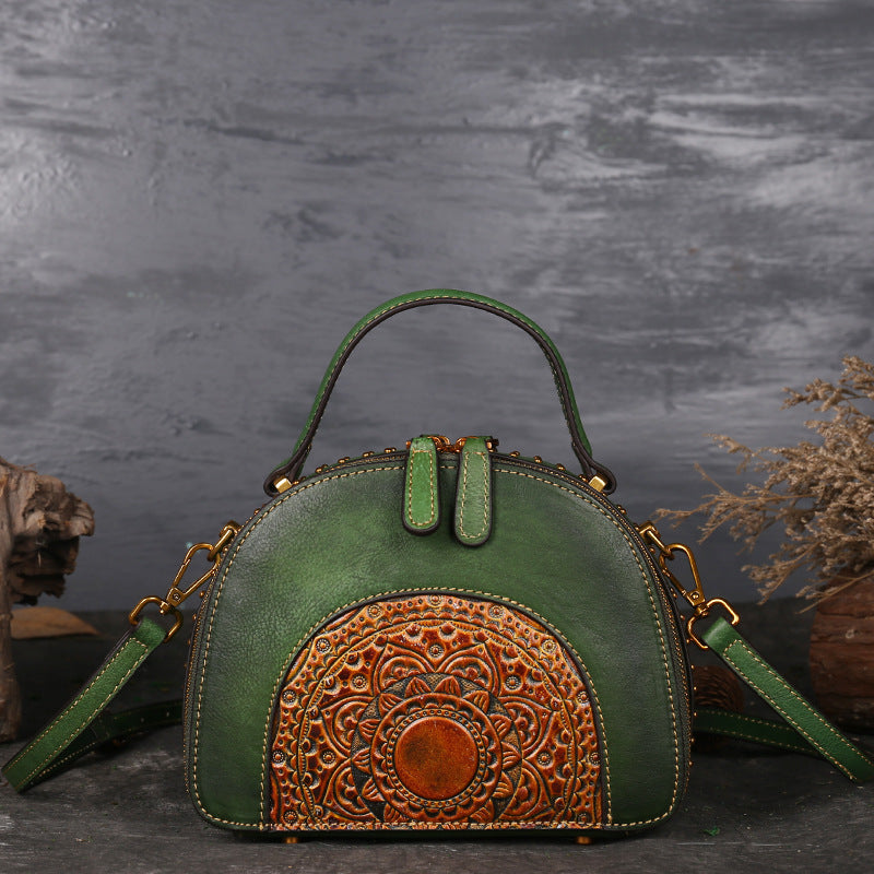 Green handbag with intricate brown leather design on a dark background