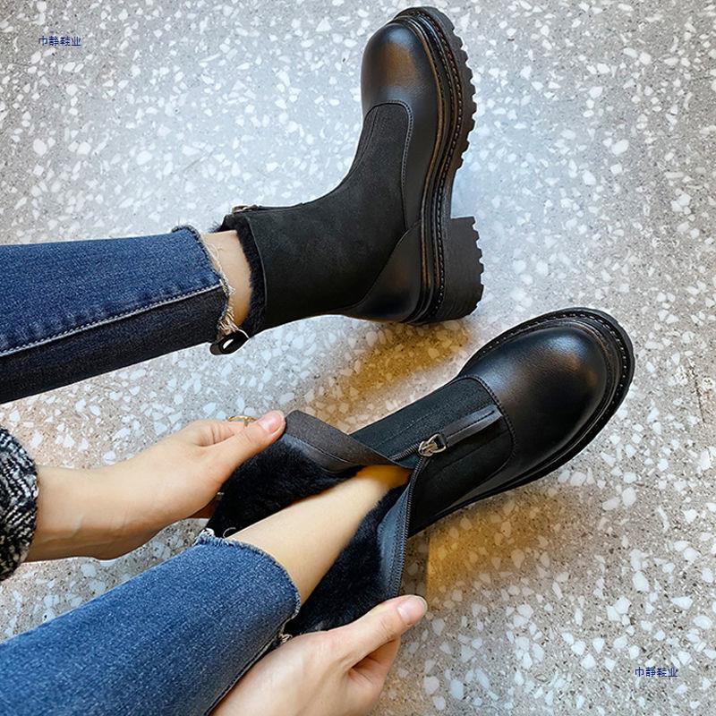Person putting on a black leather boot with a textured floor background