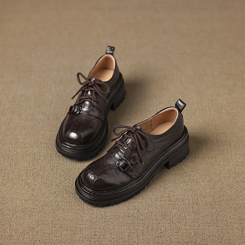 Pair of brown leather shoes on a textured beige background