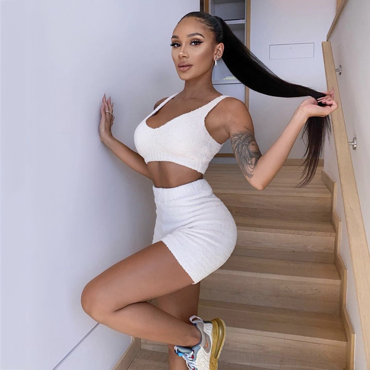 Woman in a white outfit posing on a staircase