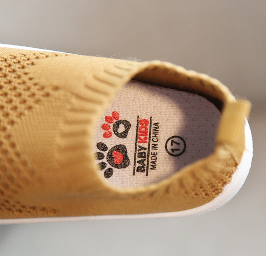 Close-up of a yellow children's shoe with a visible brand label on the insole.
