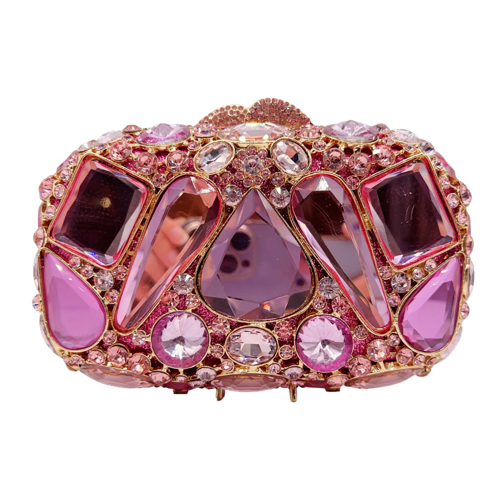 Pink clutch bag with gemstone embellishments on a white background
