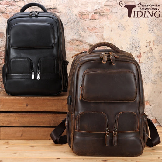 Two leather backpacks, one black and one brown, on a wooden surface with a rustic brick wall background.