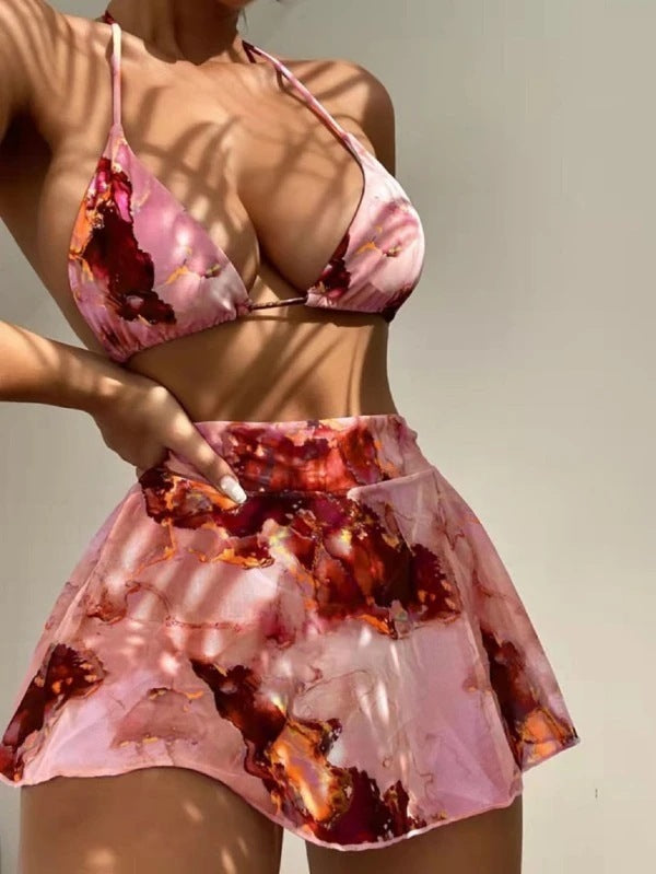 Person wearing a pink and red patterned bikini set against a neutral background