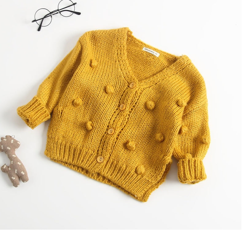 Yellow knitted cardigan with buttons on a white background