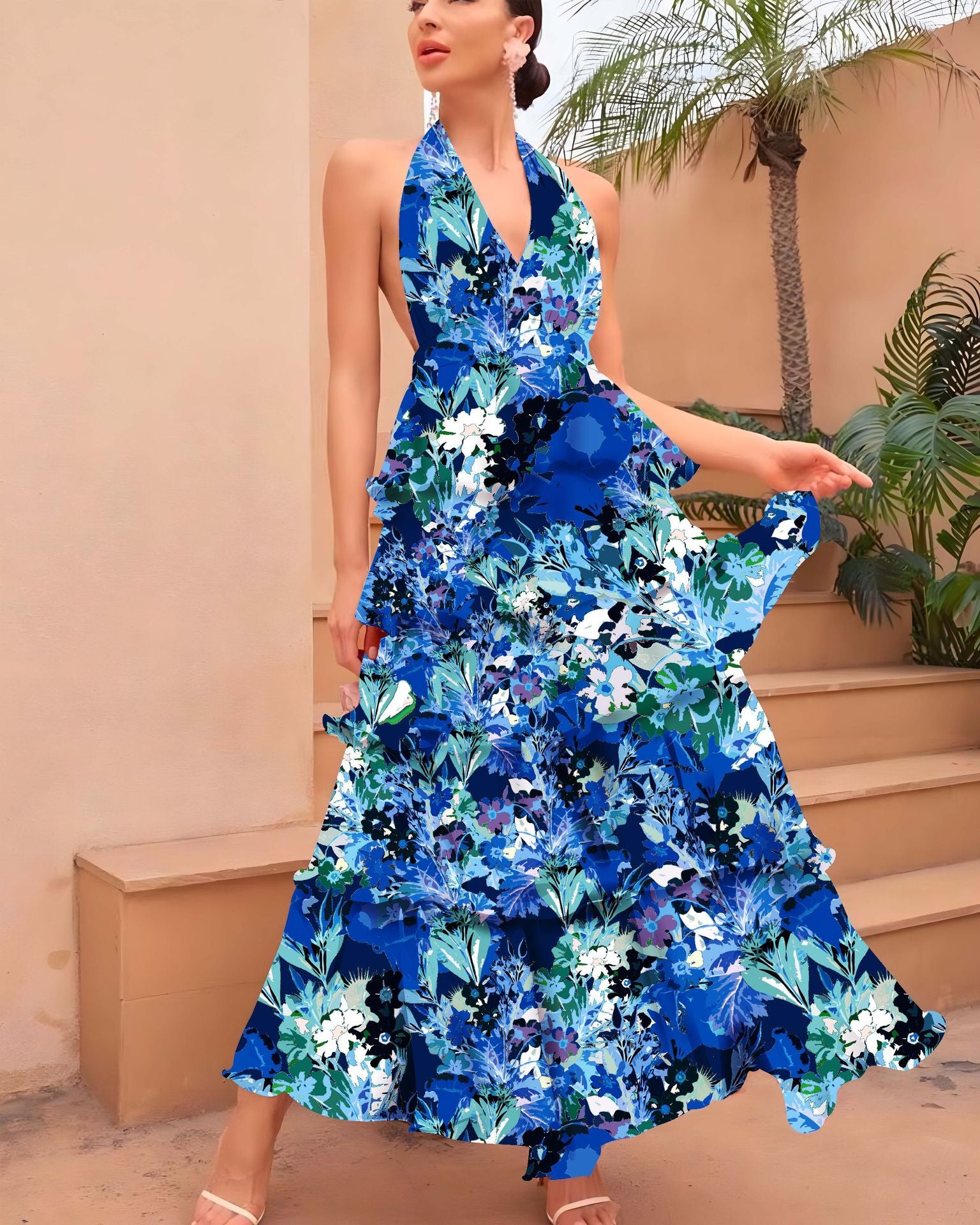 Woman wearing a blue floral dress standing outdoors with a palm tree in the background.
