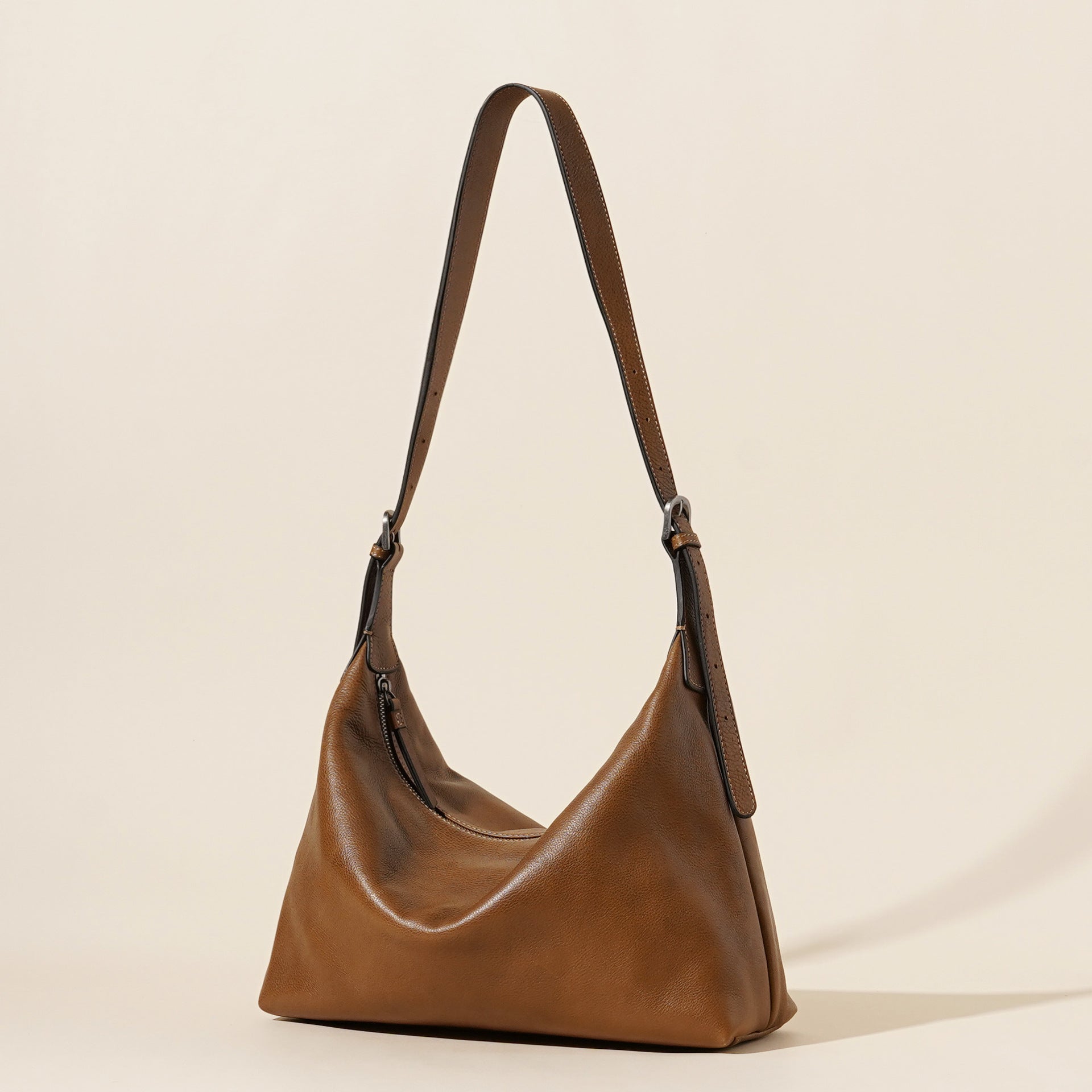 Brown leather handbag on a beige background