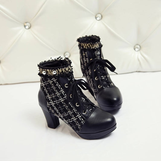 Black platform boots with tweed detailing on a white background
