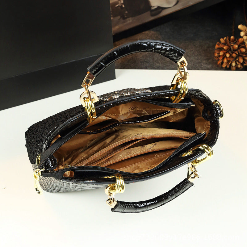 Black handbag with gold accents on a white surface