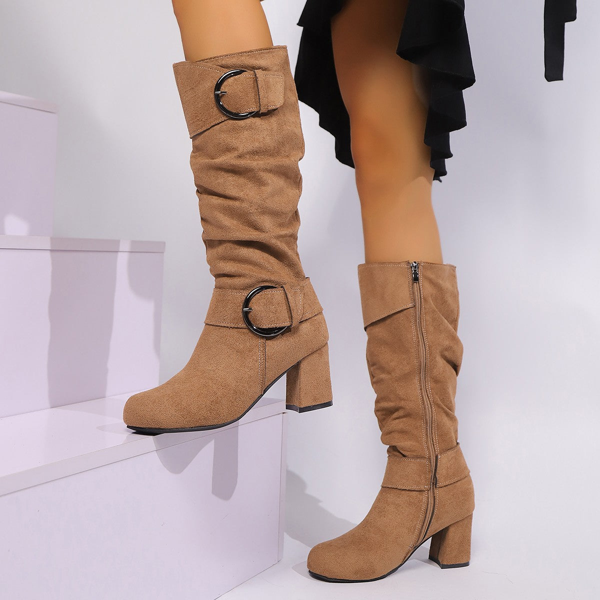 Tan knee-high boots with buckles on a white background