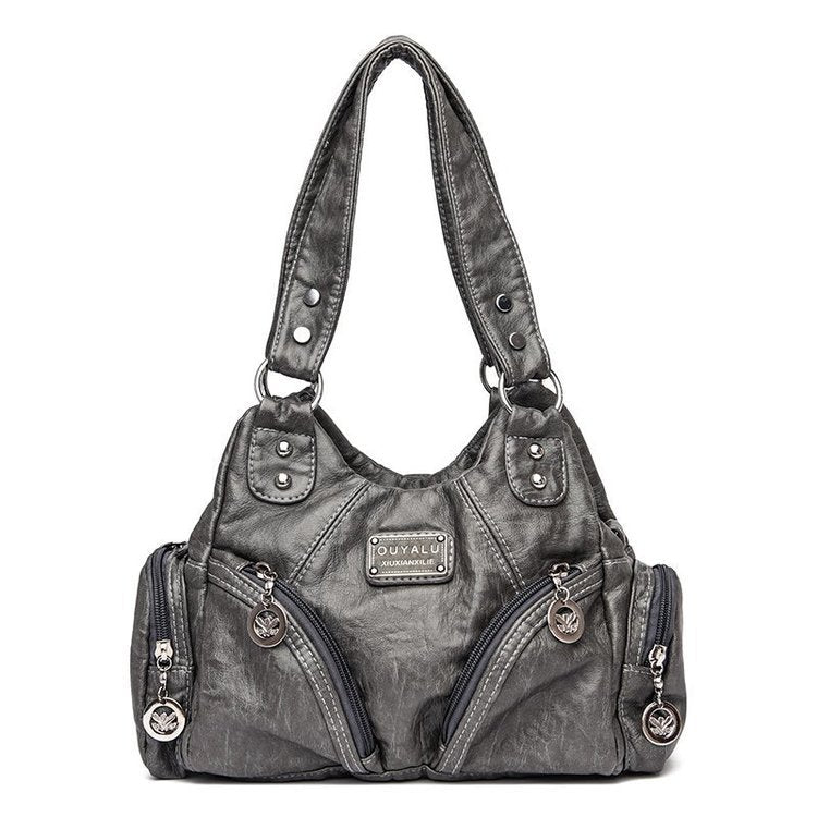 Gray handbag with multiple zippers and a visible brand logo on a white background