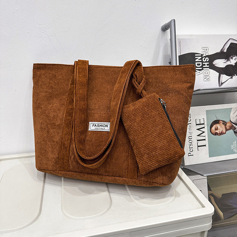 Brown corduroy tote bag with a matching pouch on a white surface.