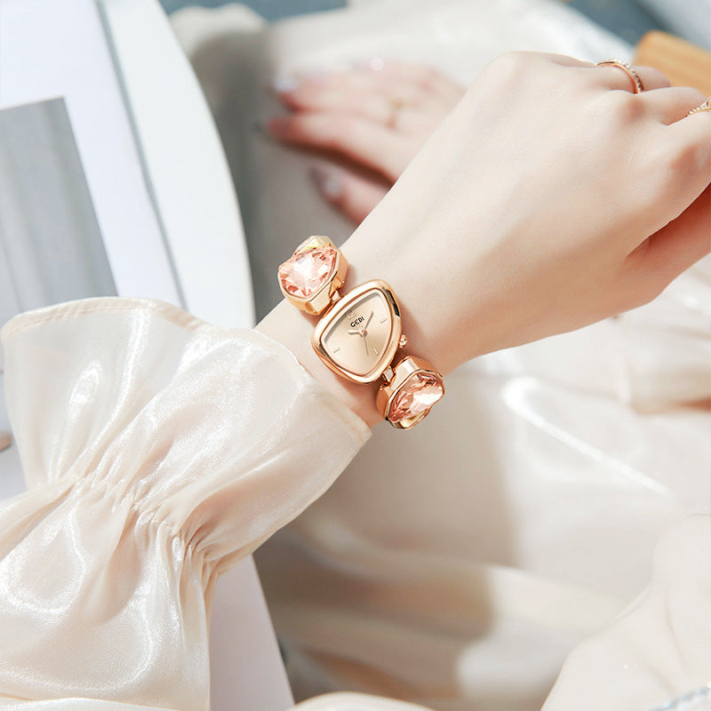 Rose gold watch on a wrist with a blurred background
