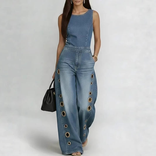 Woman wearing a blue denim jumpsuit with grommet details on a white background
