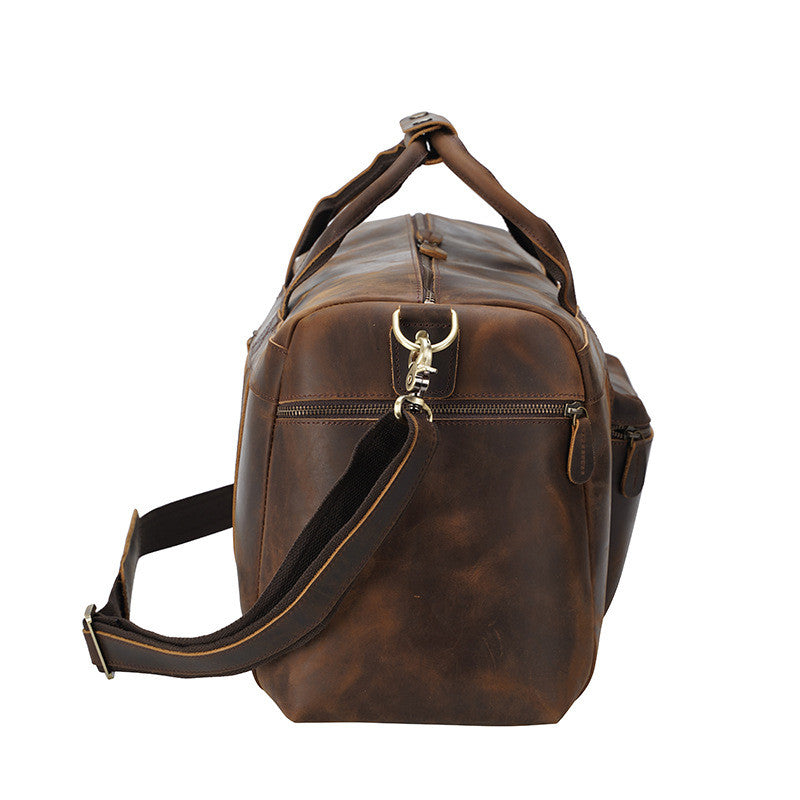Brown leather duffel bag with shoulder strap on a white background