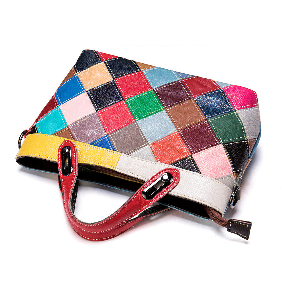 Colorful patchwork handbag with a red handle on a white background
