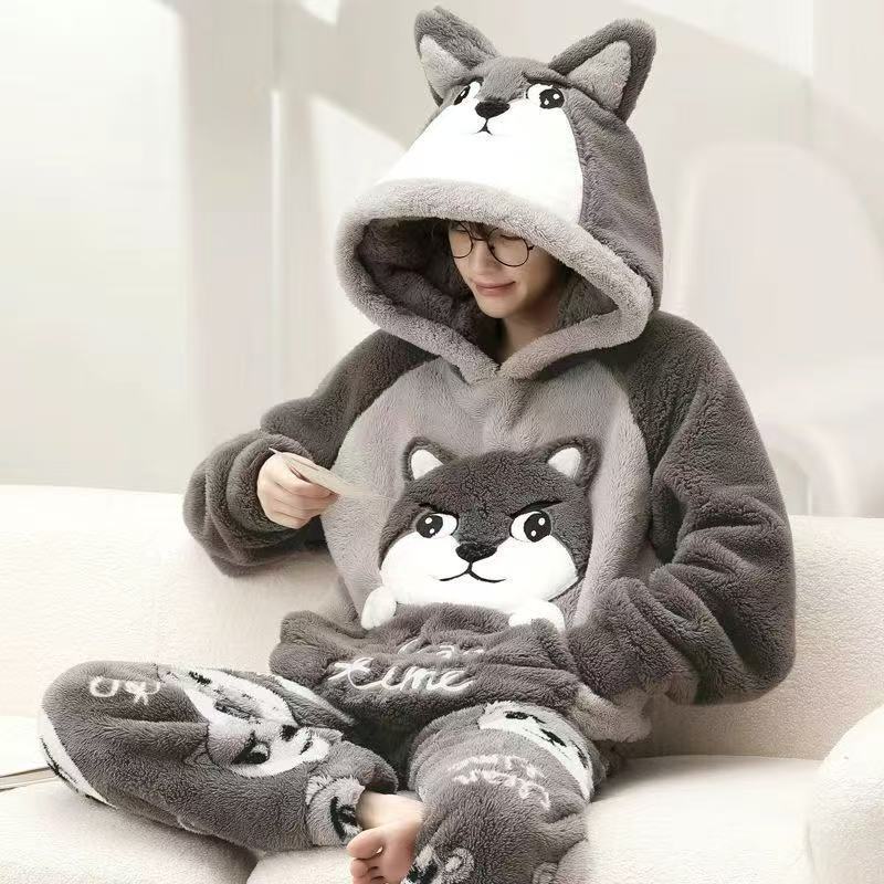 Person wearing a gray plush animal-themed onesie sitting on a white couch.