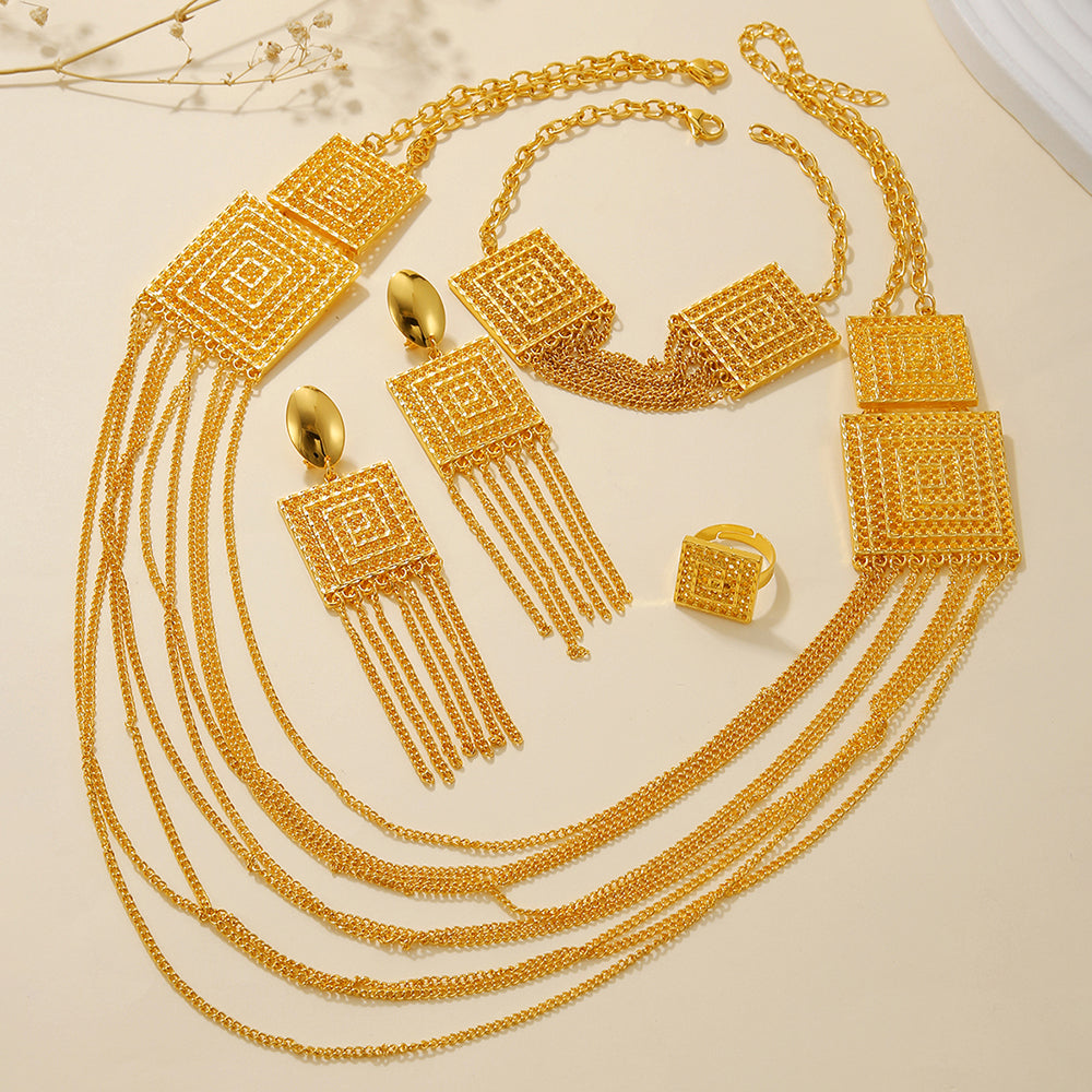 Gold jewelry set including necklace, earrings, and ring on a beige background