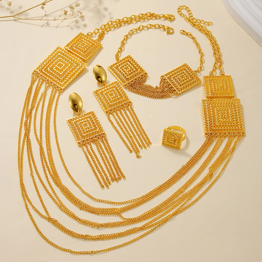 Gold jewelry set including necklace, earrings, and ring on a beige background