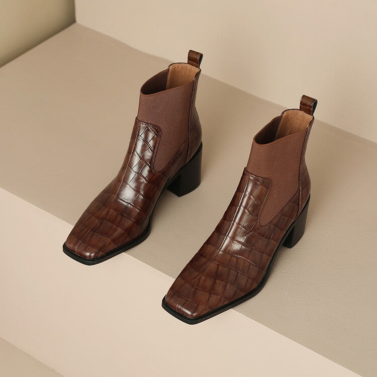 Pair of brown leather ankle boots on a neutral background