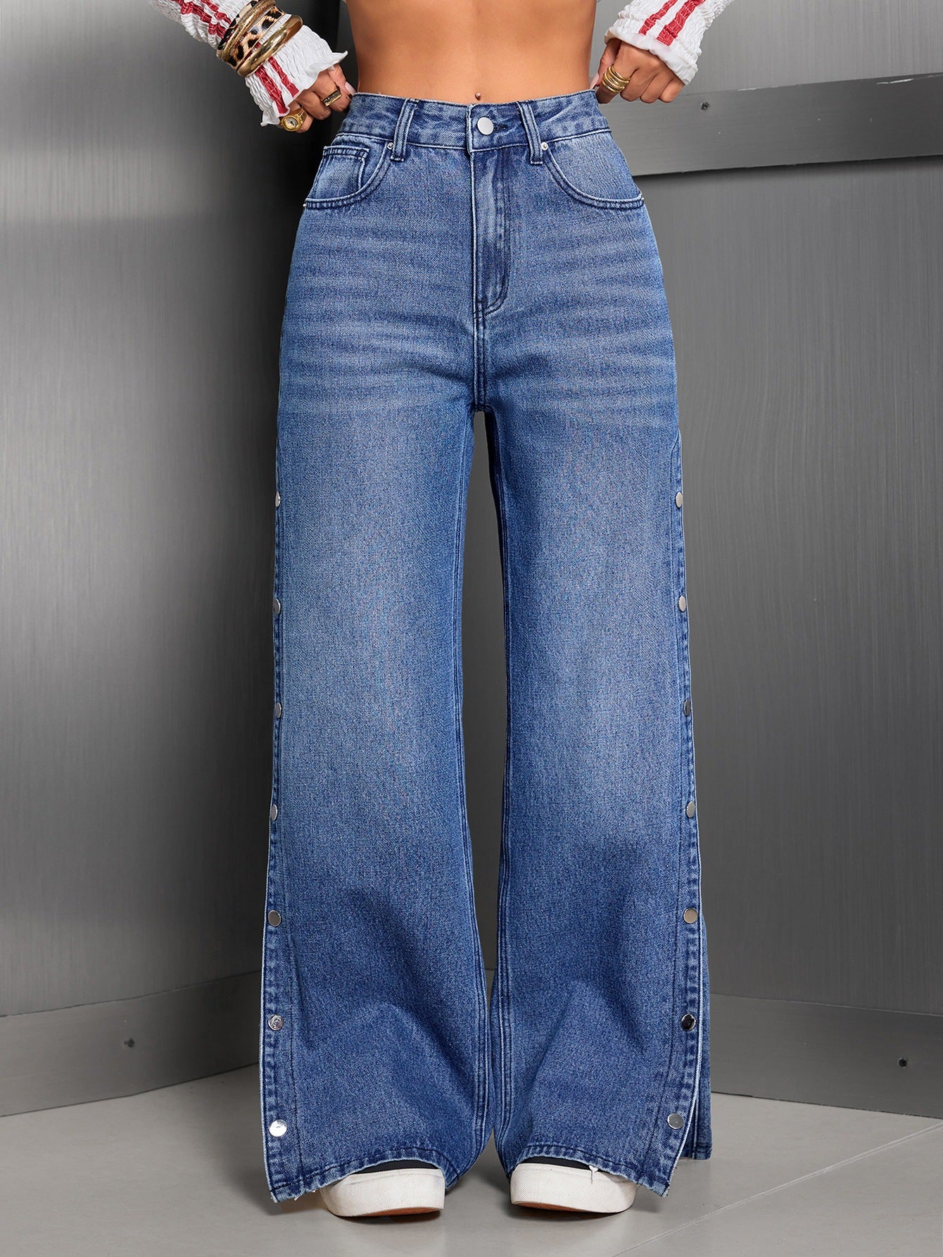 Person wearing blue wide-leg jeans against a gray background