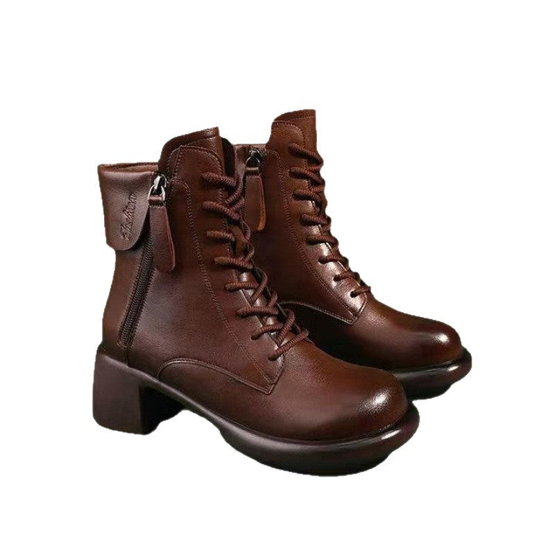 Pair of brown leather boots with laces on a white background