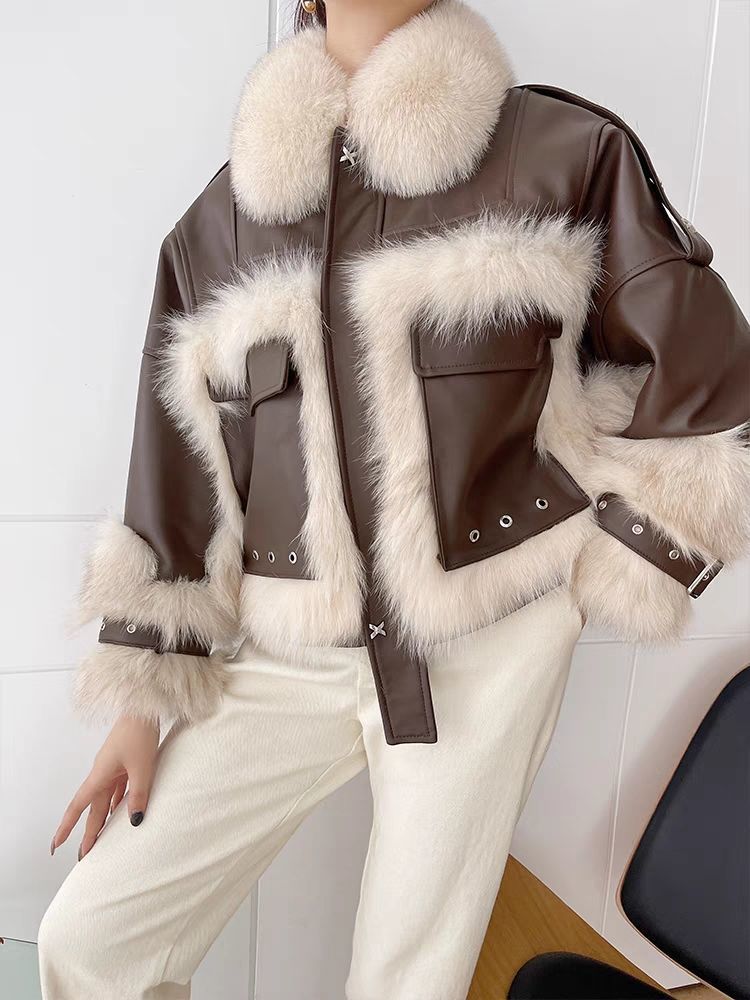 Brown leather jacket with white fur trim worn by a person against a white background
