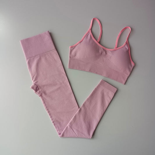 Pink sports bra and leggings set on a gray background