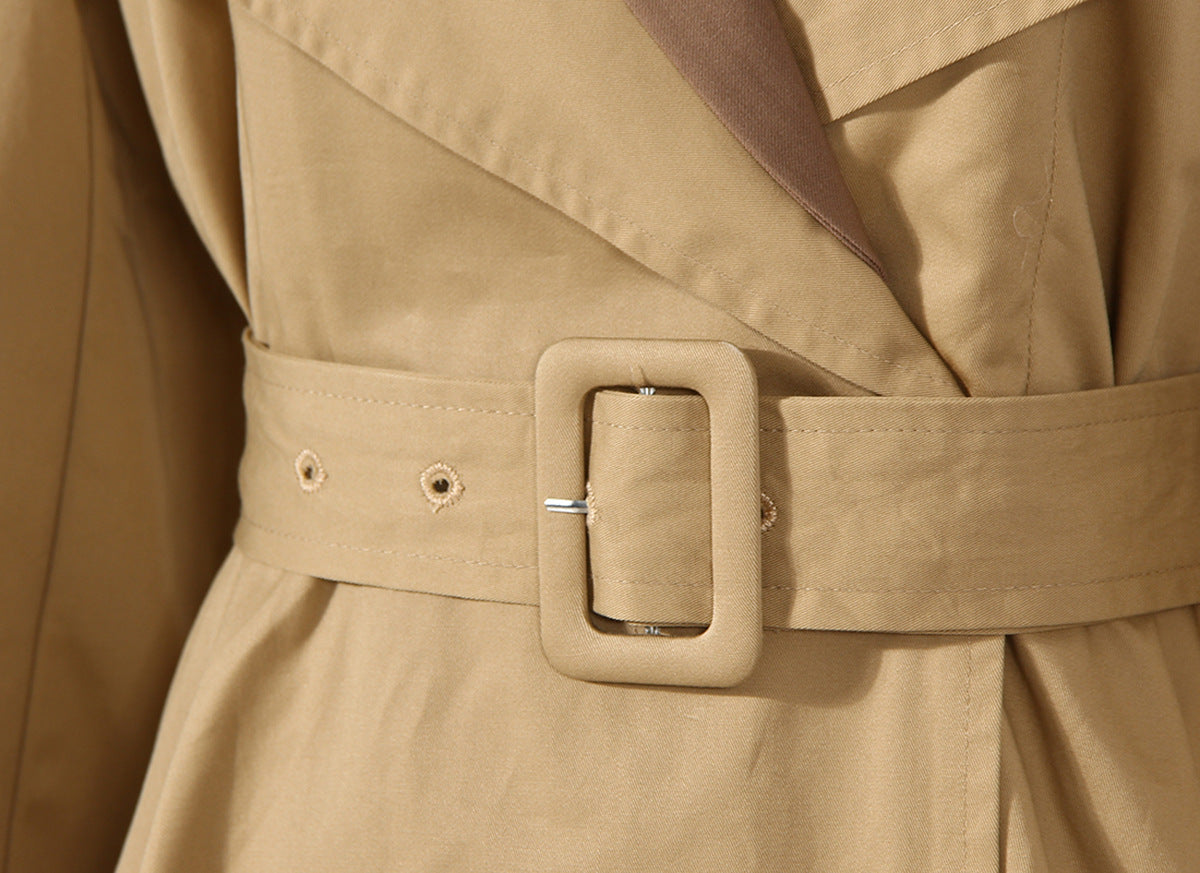 Close-up of a beige trench coat with a belt and buckle. by millivan