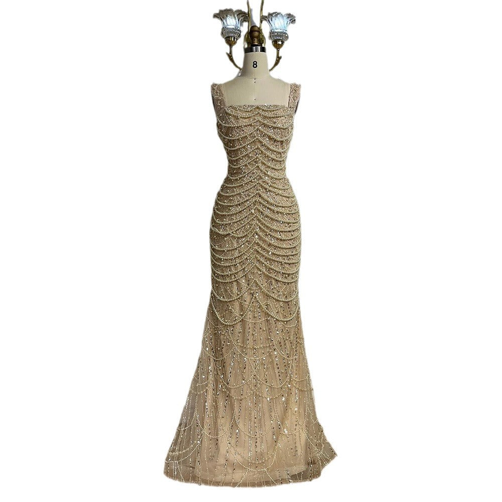 Gold beaded evening gown on a mannequin against a white background