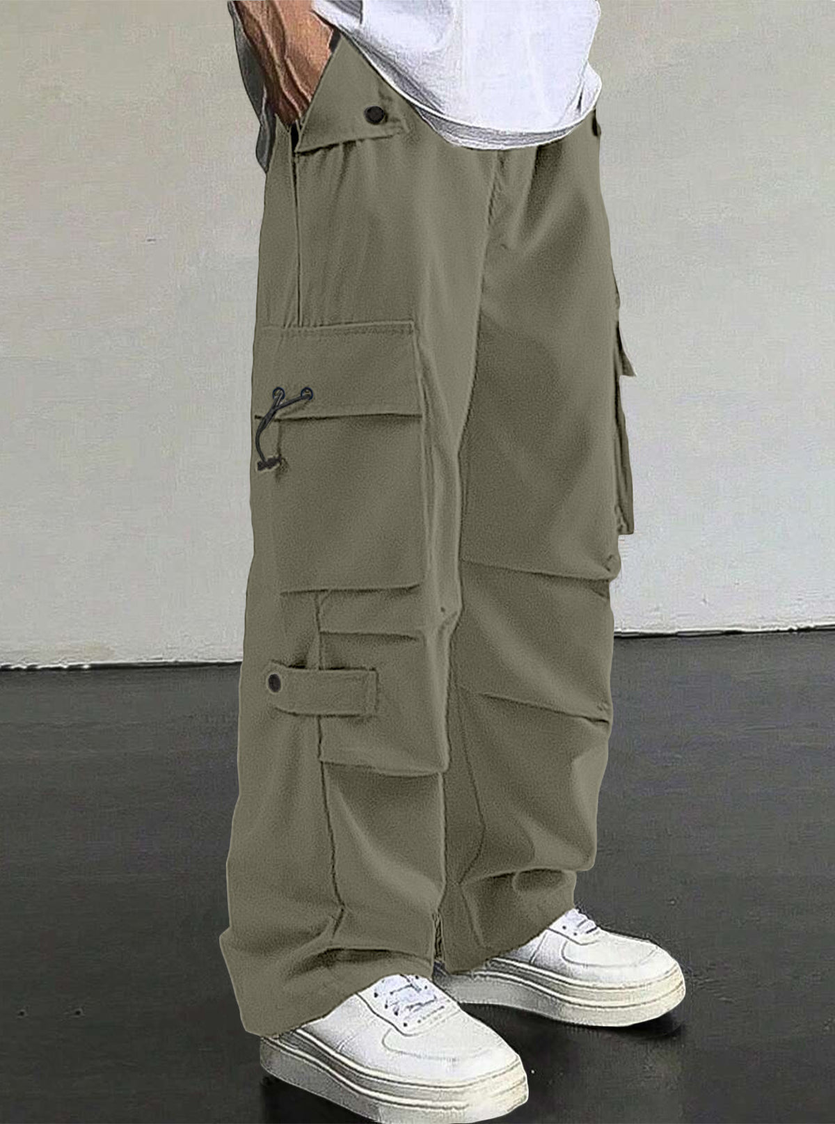 Person wearing olive green cargo pants with a white background