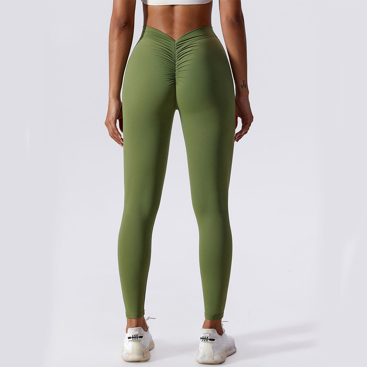Person wearing green leggings on a white background