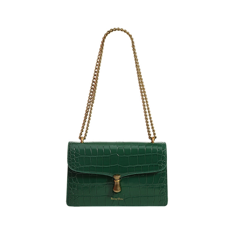 Green crocodile-patterned handbag with a gold chain strap on a white background