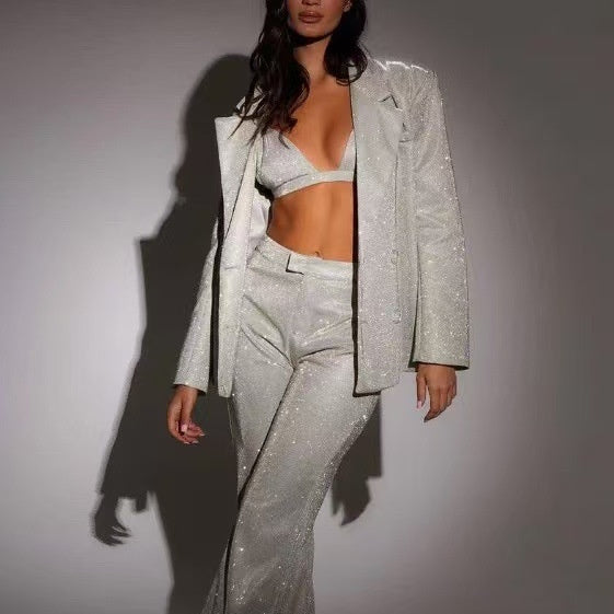Person wearing a sparkly silver outfit against a plain background