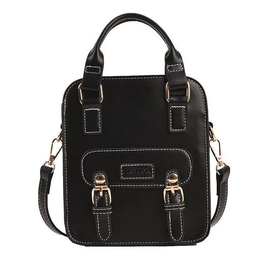 Black handbag with gold accents on a white background