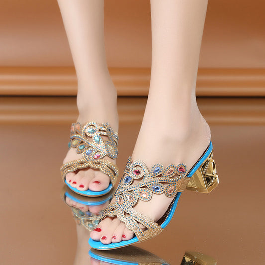 Decorative high-heeled sandals with gemstones on a reflective surface.