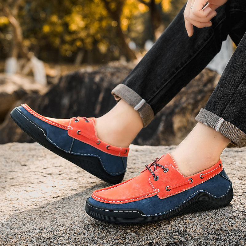 Orange and navy loafers worn outdoors on a stone surface with blurred natural background