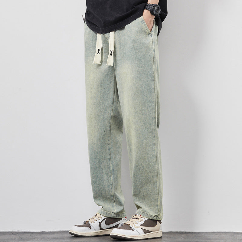 Person wearing light green jeans with a subtle gradient effect on a plain background