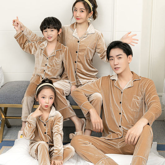 Family of four wearing matching brown pajama sets in a room.