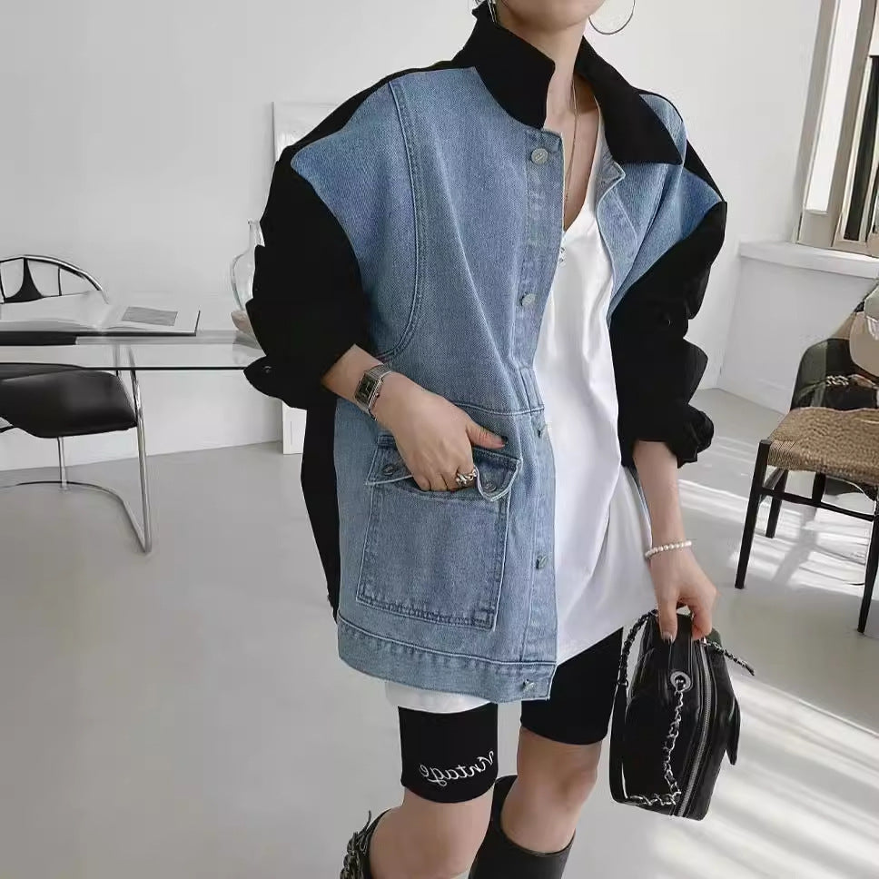 Person wearing a denim and black jacket in a modern indoor setting