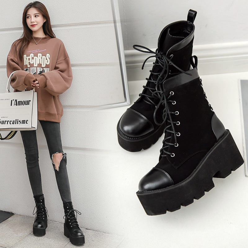 Person wearing black platform boots with a white background
