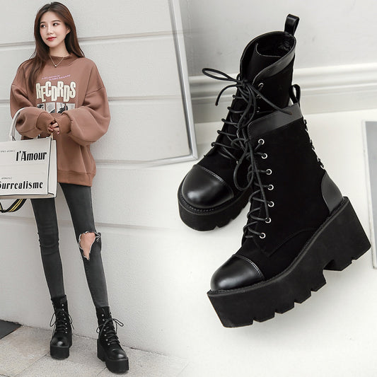 Person wearing black platform boots with a white background