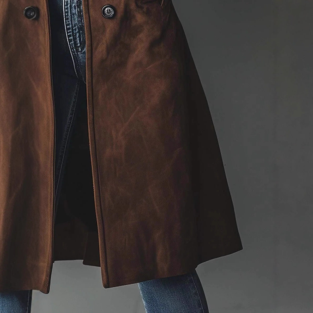 Brown leather coat worn by a person on a gray background