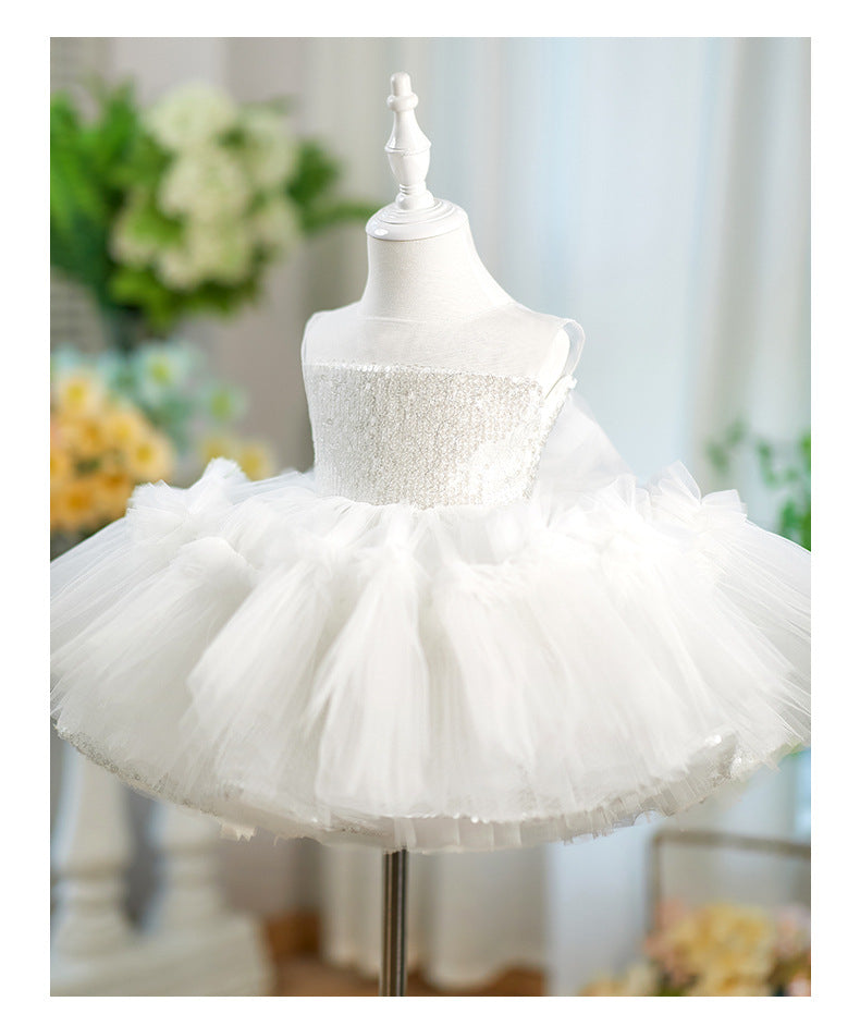White toddler girl's party dress with a beaded strapless bodice and a fluffy tulle tutu skirt, displayed on a white mannequin dress form.