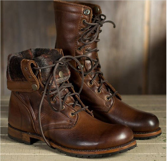 Pair of brown leather boots with lace-up design on a wooden surface.