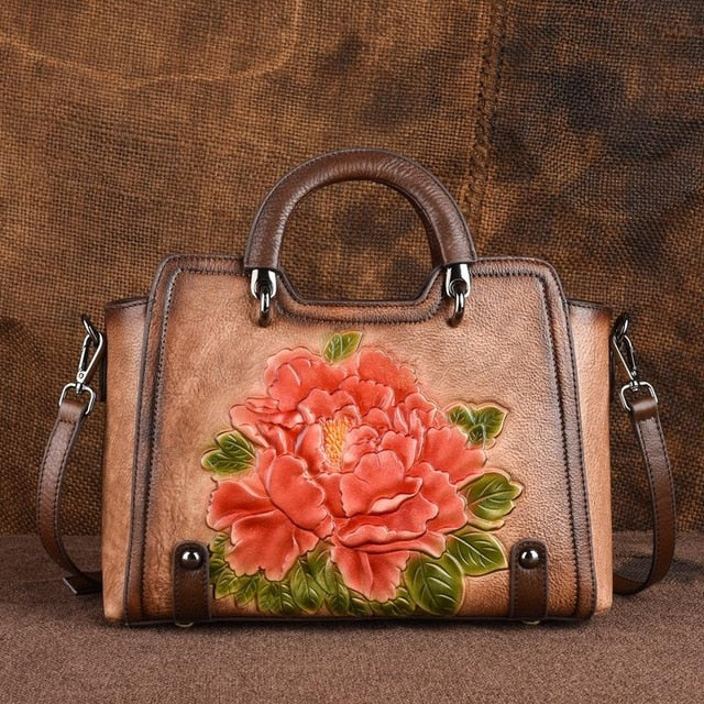 Brown leather handbag with a floral design on a brown background