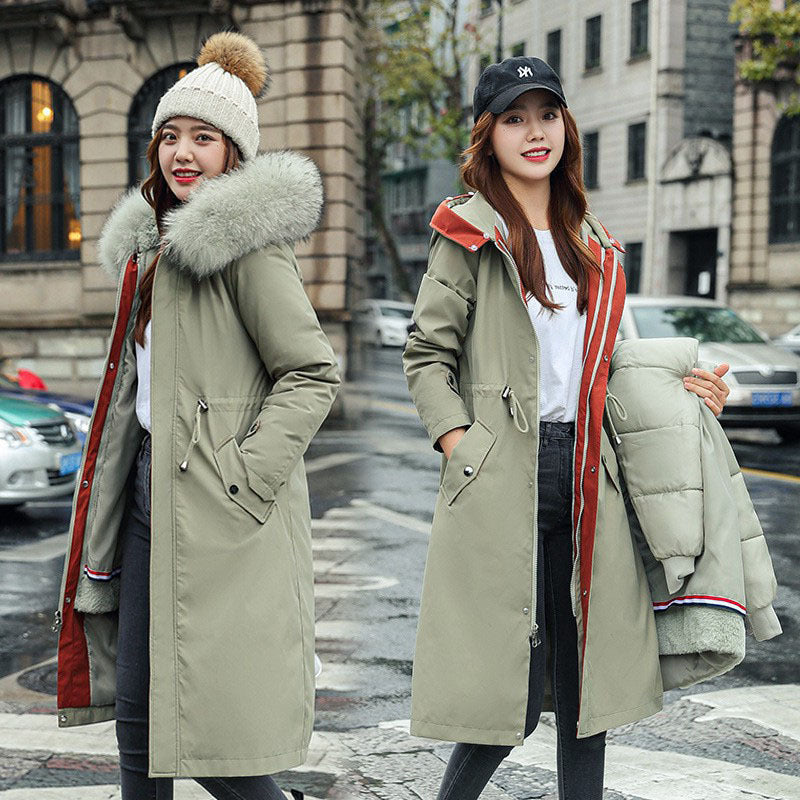 Two women wearing long winter coats with fur-lined hoods on a city street.